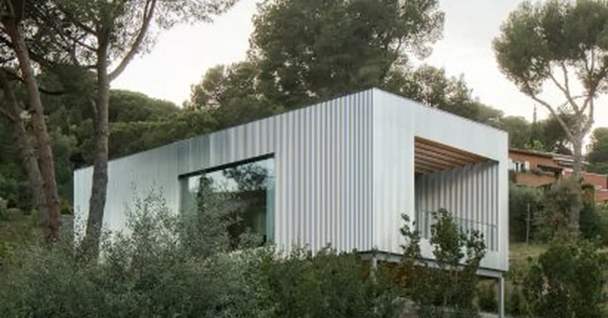 Metal-clad home perched on steel supports above Barcelona coast